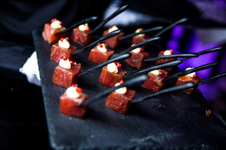 Luxurious buffet. Tuna with cheese on a black spoon.の写真素材