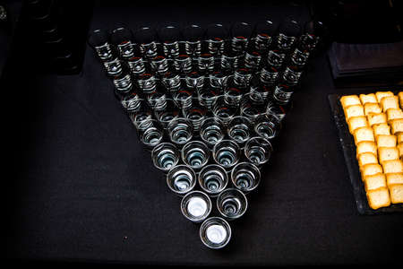 Glasses of whiskey on a buffet table in the form of a triangle.