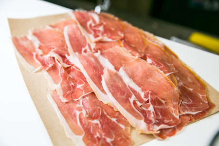 Sliced jamon prosciutto on a a paper photoの写真素材