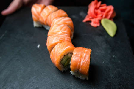 Philadelphia sushi roll with salmon, cucumber, avocado, cream cheese. Sushi menu. Japanese food. On...