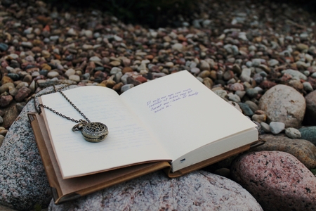 vintage clock on the open book on a background of stonesの写真素材