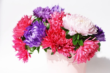 Bouquet of autumn flowers asters background in a decorative bucketの写真素材