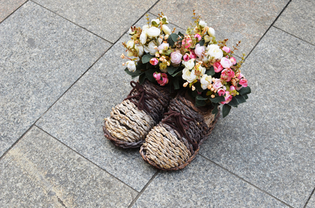 Bouquet of flowers in wattled boots placed in the streetの写真素材