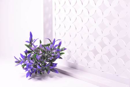 Purple flowers on a decorative openwork white backgroundの写真素材