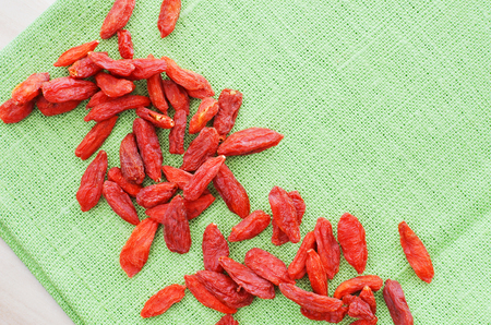 red dried goji berry on green flex material table cloth background, superfood, healthy snackの写真素材