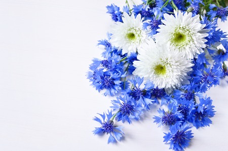 blue cornflowers and white daisy bouquet over white background, copy spaceの写真素材