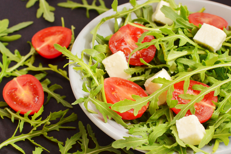 salad with tomatoes, fresh arugula and mozzarellaの写真素材