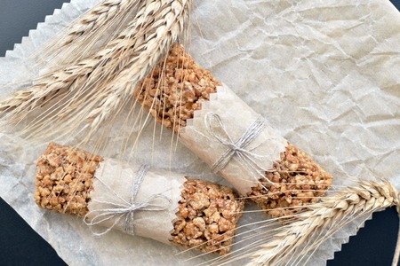 two muesli bars with wheatear on backing parchment backgroundの写真素材