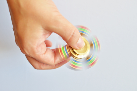 Male hand holding popular fidget spinner toyの写真素材