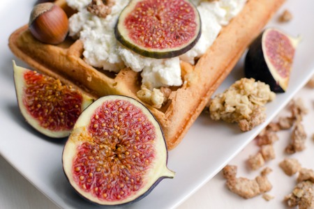 Vienna wafer dessert with ricotta, filbert nuts and fresh figs on white plate background, healthy food conceptの写真素材