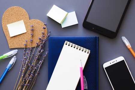 working place flatlay with leather personal organizer and notepad, stationery, smartphone and...