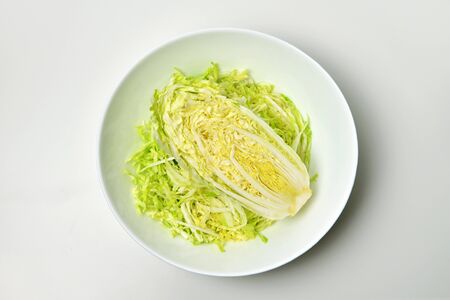 Chinese cabbage leaves salad in white bowl over white. Vegan food lifestyle concept.の写真素材
