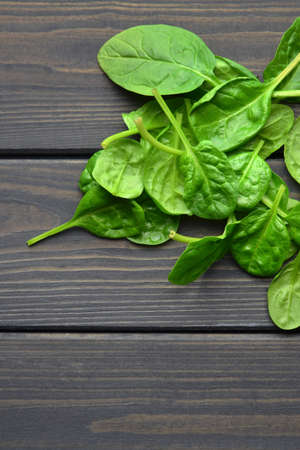 Spinach leaves on wooden table background. Healthy vegan food. Green living concept. Copy space.の写真素材