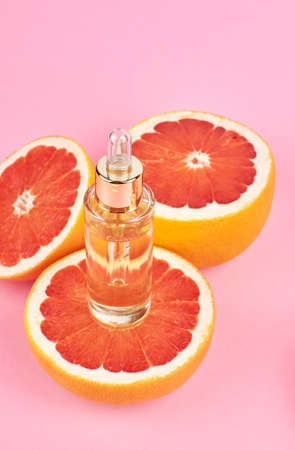 Aromatherapy - Pure essential oil in bottle with fresh grapefruit halves. Citrus beauty oil.の写真素材