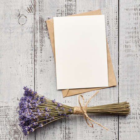 Greeting card with copy space and dry lavender flowers on vintage wooden background, top viewの写真素材