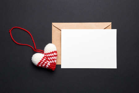 Valentines day card with copy space and knitted heart on black paper background, top viewの写真素材