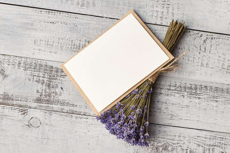 Invitation card with copy space and lavender flowers bunch on wooden backgroundの写真素材