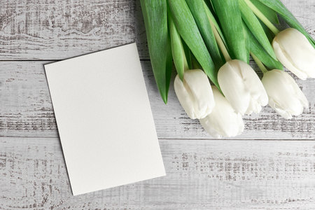 Greeting card with copy space and tulip flowers bouquet on wooden background, top viewの写真素材