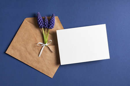 Invitation or greeting card mockup with envelope and spring blue muscari flowers