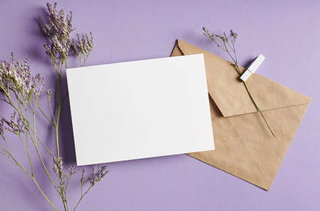 Invitation or greeting card mockup with envelope and dry limonium flowers on lavender color backgroundの写真素材