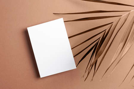 Invitation card mockup with palm tree leaf decoration, top viewの写真素材