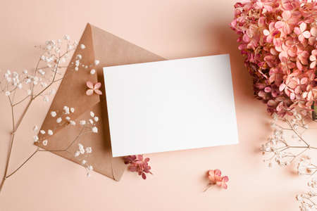Invitation or greeting card mockup with envelope, hydrangea and gypsophila flowers. Blank card...