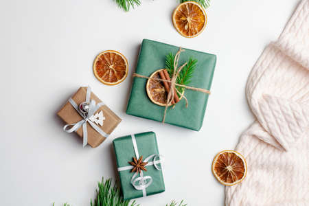 Christmas flat lay with decorated gift boxes and dry oranges on whiteの写真素材