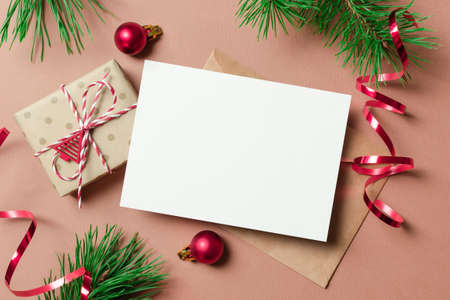 Christmas or New Year greeting card mockup with gift box, envelope and festive decorationsの写真素材