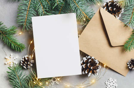 Christmas or New Year greeting card mockup with envelope and lighting garlands, top viewの写真素材