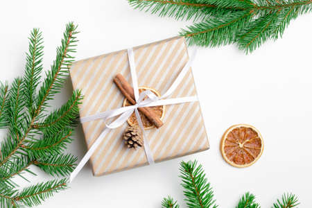 Decorated christmas gift box with fir tree branches on white