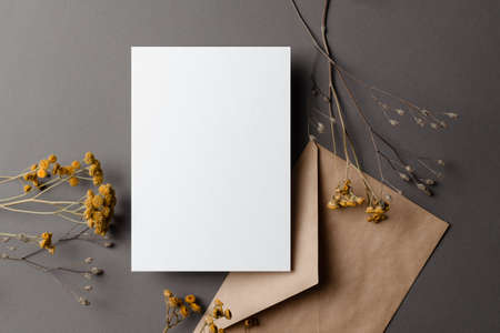 Invitation or greeting card mockup with dry flowers twigs and envelopeの写真素材