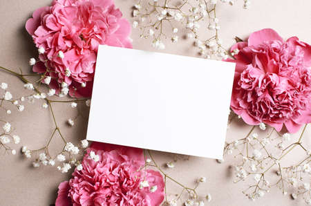 Wedding invitation card mockup with pink peony and gypsophila flowers, top view, copy spaceの写真素材