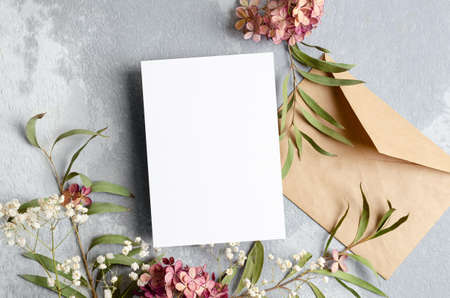Wedding invitation or greeting card mockup with envelope and dry flowers decorations.の写真素材