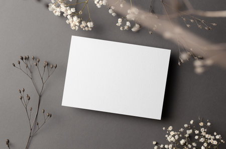 Wedding invitation card mockup with dry flowers twigs on grey, top view, copy spaceの写真素材