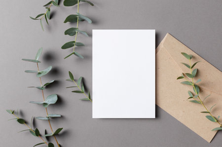 Blank wedding botanical invitation card mockup with fresh eucalyptus and envelope on grey backgroundの写真素材