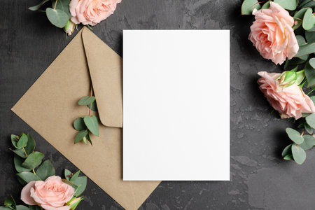 Invntation or greeting card mockup with envelope and roses flowers on dark background, blank mockupの写真素材