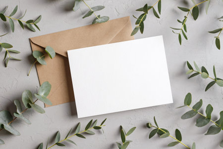 Blank greeting card mockup with envelope and eucalyptus twigs decorationsの写真素材