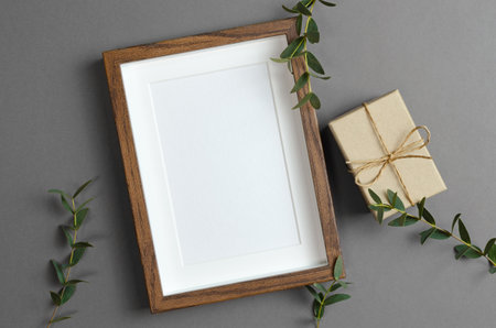 Blank frame mockup with gift box for artwork, photo or paintings presentationの写真素材