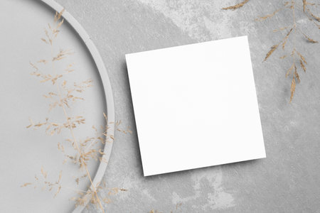 Square paper botanical card mockup with copy space on grey stony background, top viewの写真素材