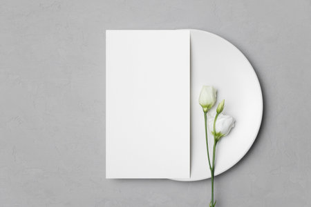 Wedding menu card mockup on white plate with eustoma flower, blank card mock up with copy spaceの写真素材