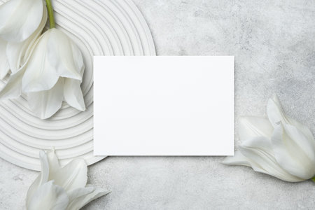 White wedding invitation card mockup with tulips flowers, copy space for card design, blank card mock upの写真素材