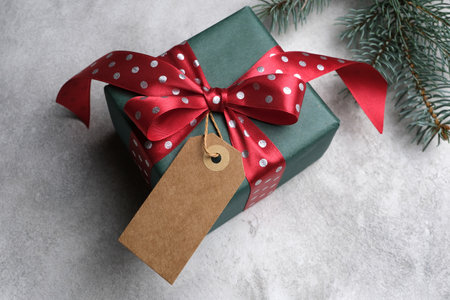 Decorated Christmas or New Year gift box with craft cardboard gift tag, mockup, copy space, top view
