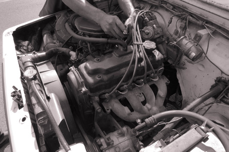 Closeup of male hands repairing the inner part of the old machine. Visible wire, engine, fuel...