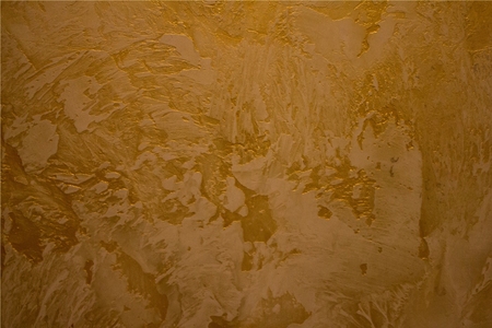 Embossed texture in gold. Large, sharp strokes of decorative plaster.の写真素材
