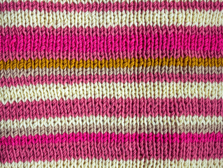 Warm knitted thing made of natural wool. Bright, colored, horizontal stripes of various widths. Handmade.の写真素材
