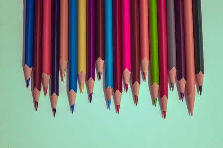 A number of bright, sharply sharpened pencils of different colors. Brainstorming, task for creativity of thinking, teamwork. Light background, top view.の写真素材