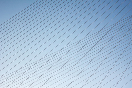 Thin gray strips on a blue background form a grid. Graphic, abstract ornament. Solar illumination...