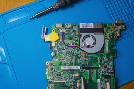 Preparing to replace the fuse on the motherboard. The dismantled interior from the laptop, next to...