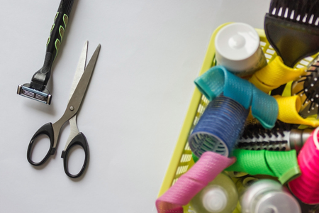 Scissors, shaving machine and waste basket in which curlers, shampoos and hair combs. Do not worry, live easier! Do not complicate things. Light background, vertical arrangement.の写真素材