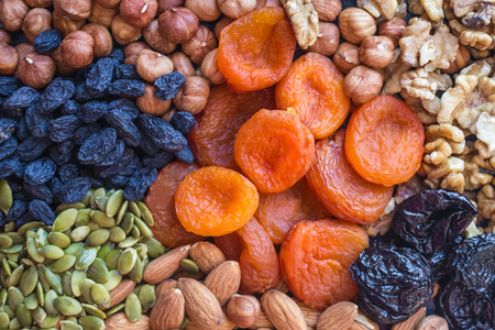 Dried apricots, nuts of different varieties and raisins. Useful, simple, satisfying, tasty food. Menu without meat, sources of vegetable protein. Top view, daylight.の写真素材